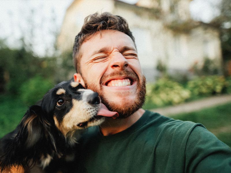 guy getting licked by a dog